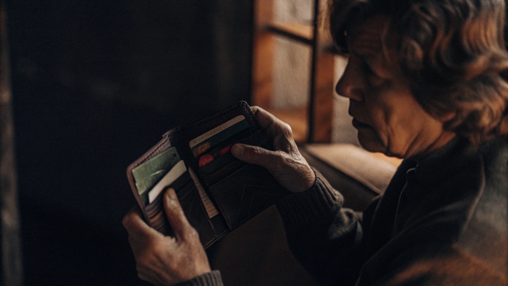 Пожилая женщина проверяет кошелёк